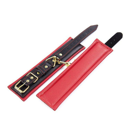 Red and black BDSM wrist restraints with gold buckles