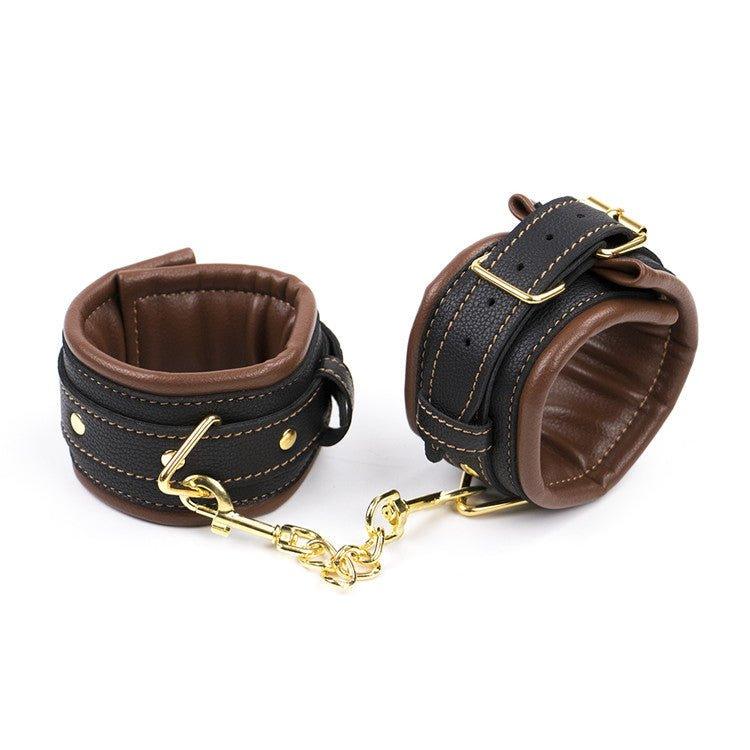 Brown and black BDSM handcuffs with gold chain