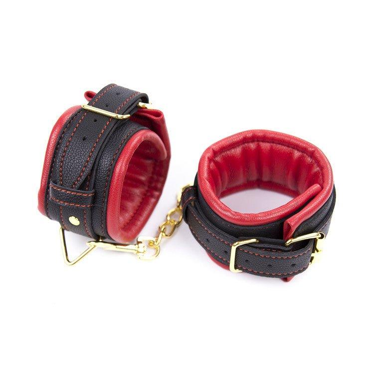 Red and black BDSM handcuffs with gold chain