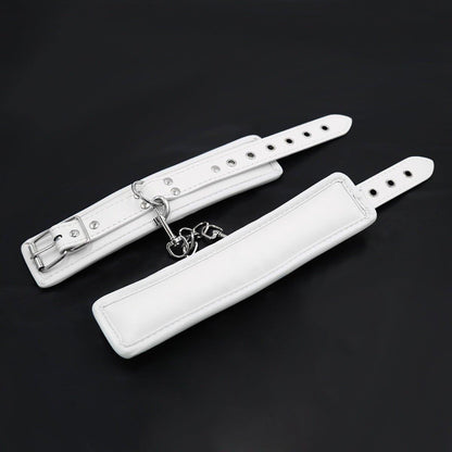 White BDSM wrist restraints with silver buckle