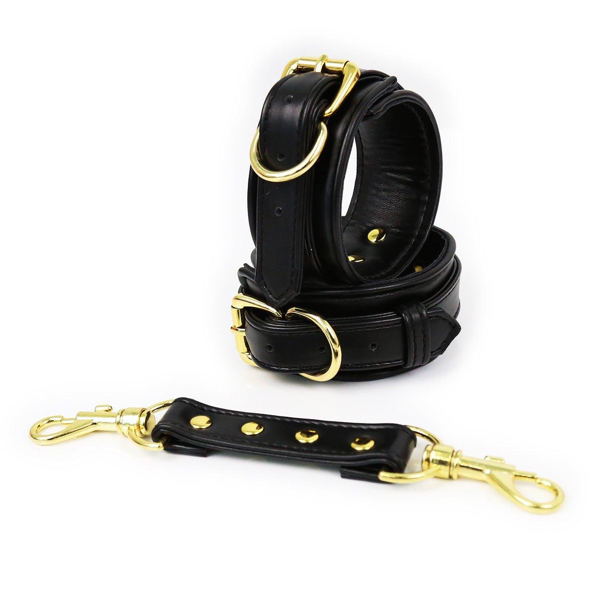 Black faux leather hand cuffs with gold buckles